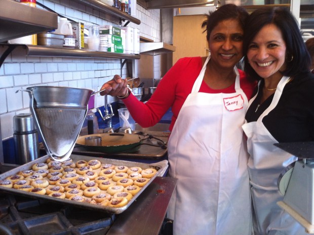Jenny and Maria adding powdered sugar to the thumbprint cookies